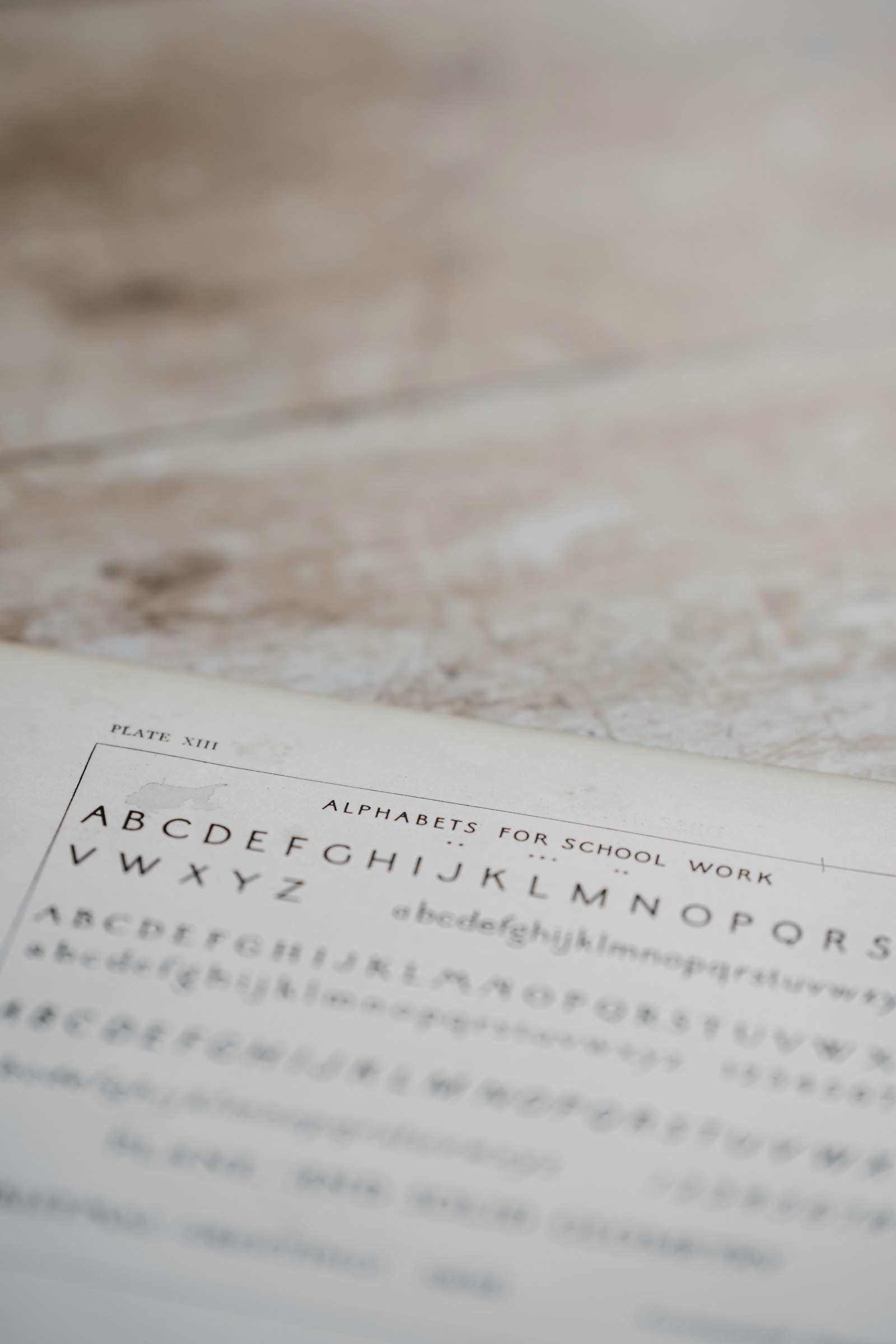 A vintage alphabet reference sheet laid on a desk